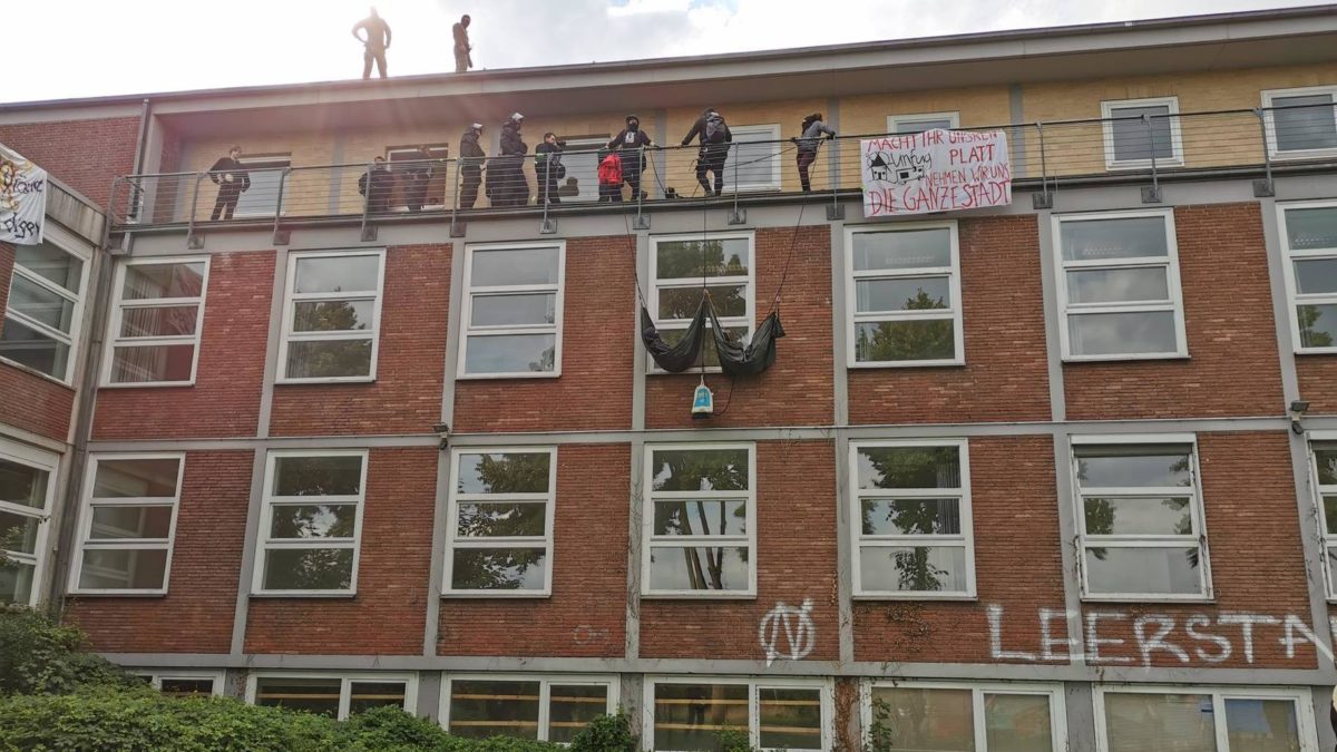 Hausbesetzung mit Menschen auf dem Dach, auf einem Balkon und in Seilen hängend an der Fassade, Juli 2020