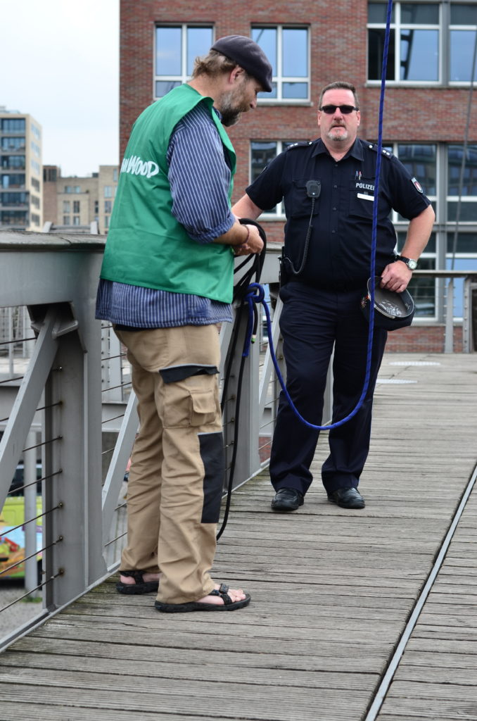 Karsten mit Seilen in der Hand, daneben ein Polizist