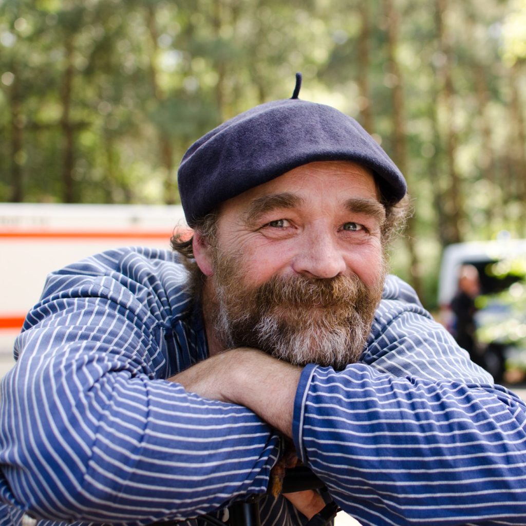 Porträt von Karsten Hilsen, er lächelt in die Kamera, trägt eine baskenmütze