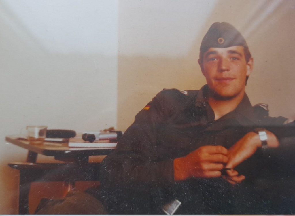 Mensche in Bundeswehr Uniform in einem Raum mit Tisch