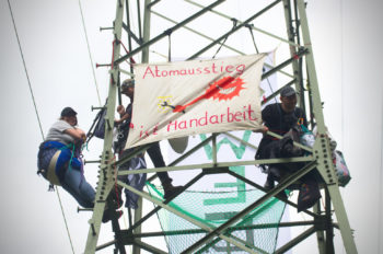 Strommastbesetzung mit Banner " Atomausstieg ist Handarbeit"