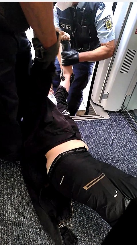 Polizei schleift eine Person aus einem Zug