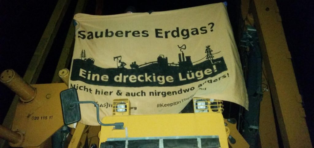 Transpi auf einem Bagger: Sauberes Erdgas? Eine dreckige Lüge! ist darauf zu lesen